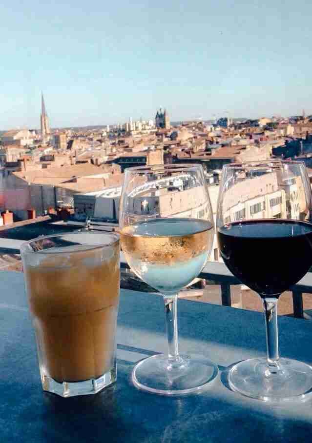 3 drinks sitting on a bar overlooking the city of Bordeaux skyline