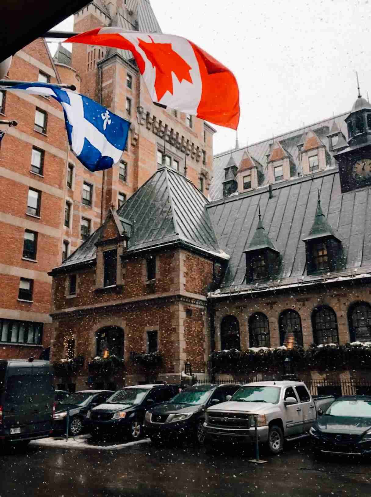 Views from inside the chateaux Frontenac in Quebec city looking at the detailed castle walls with a Canadian and Quebec flag flying in the foreground
