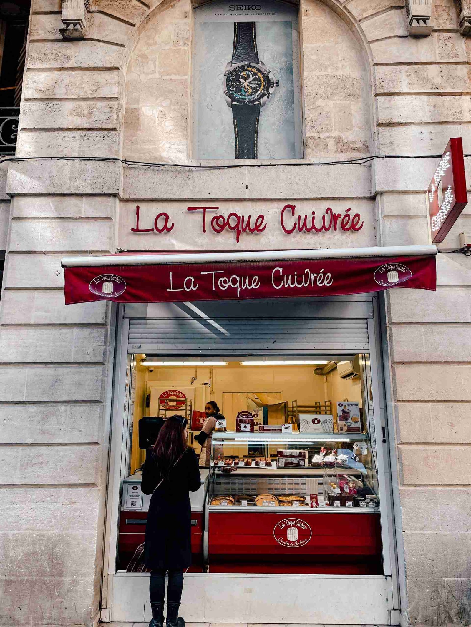 Someone standing in front la toque cuivre storefront