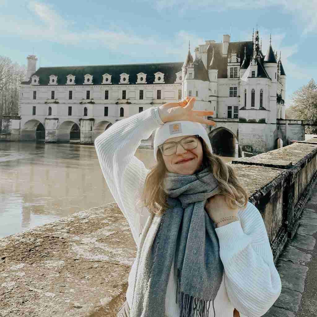 girl smiling in front of a castle
