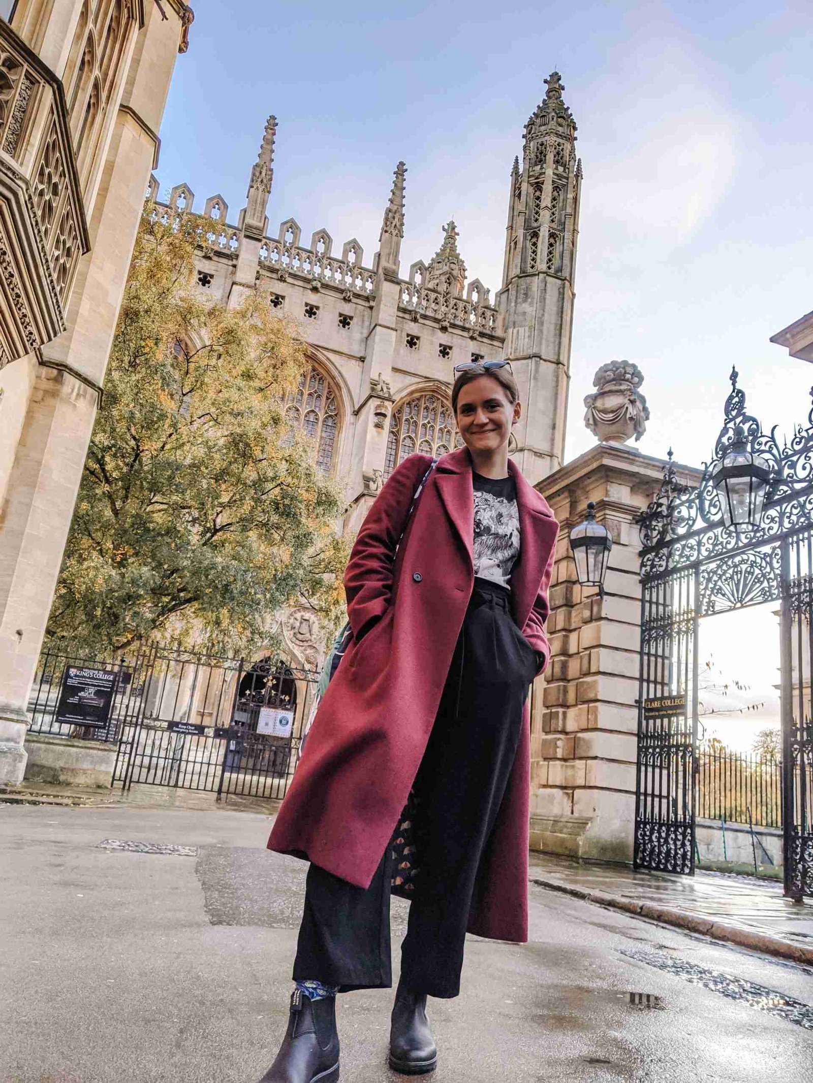 a girl standing in front of one of the Cambridge university buildings - one of the most popular day trips from London