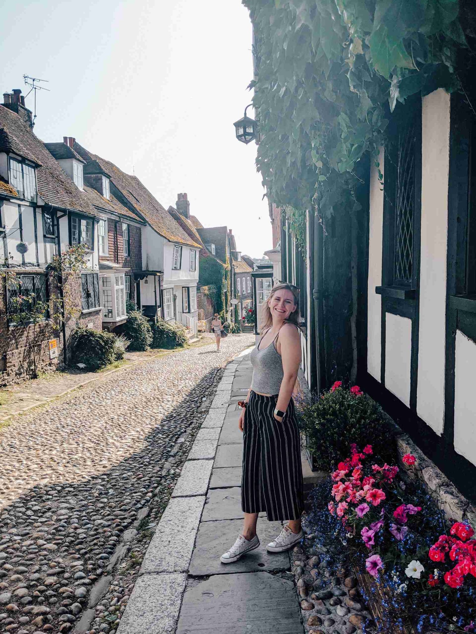 the a girl standing in front of a timber-framed street in Rye - an underrated day trip from London