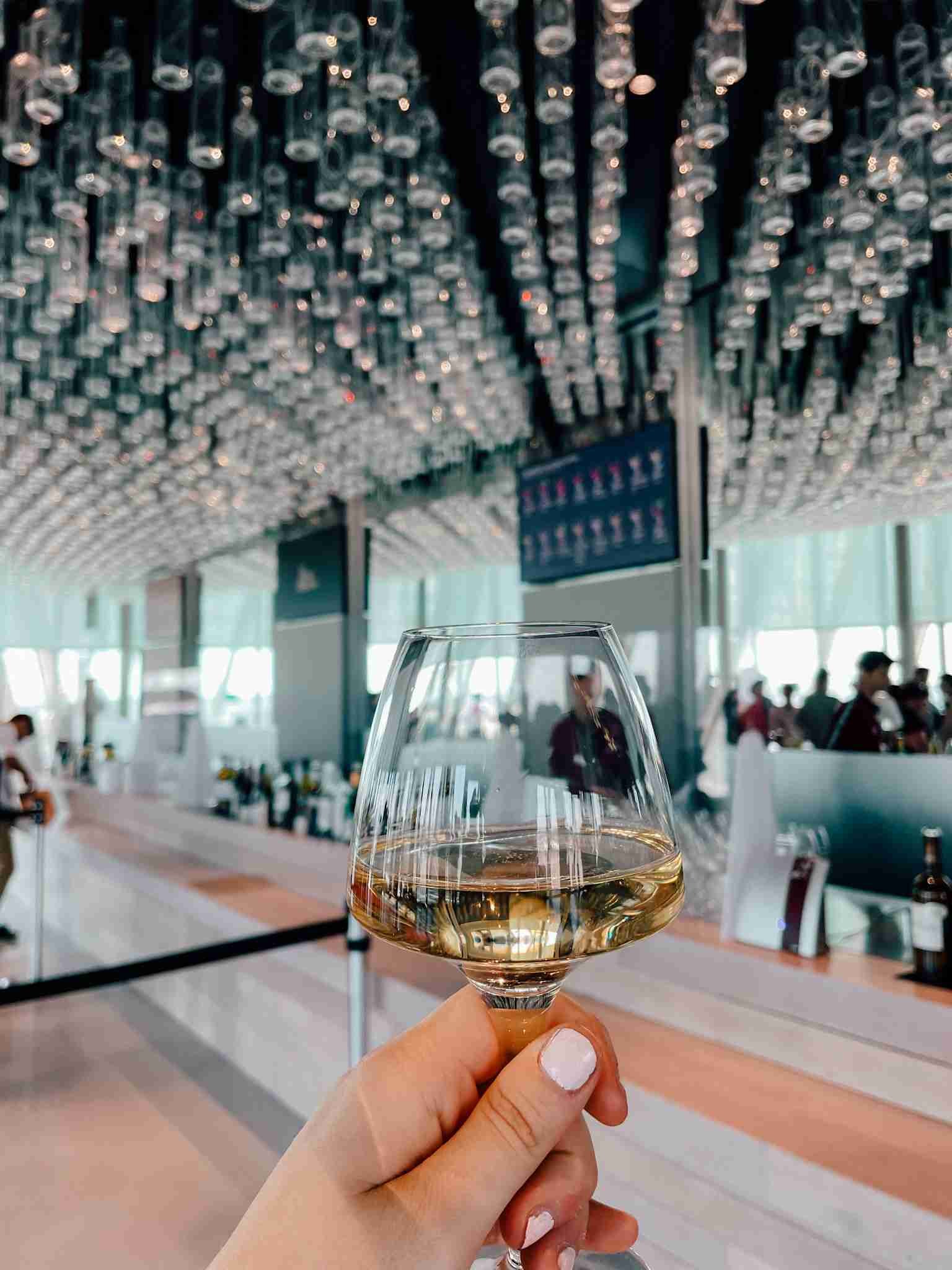 someone holding a glass of wine at the top of the Wine Museum in France