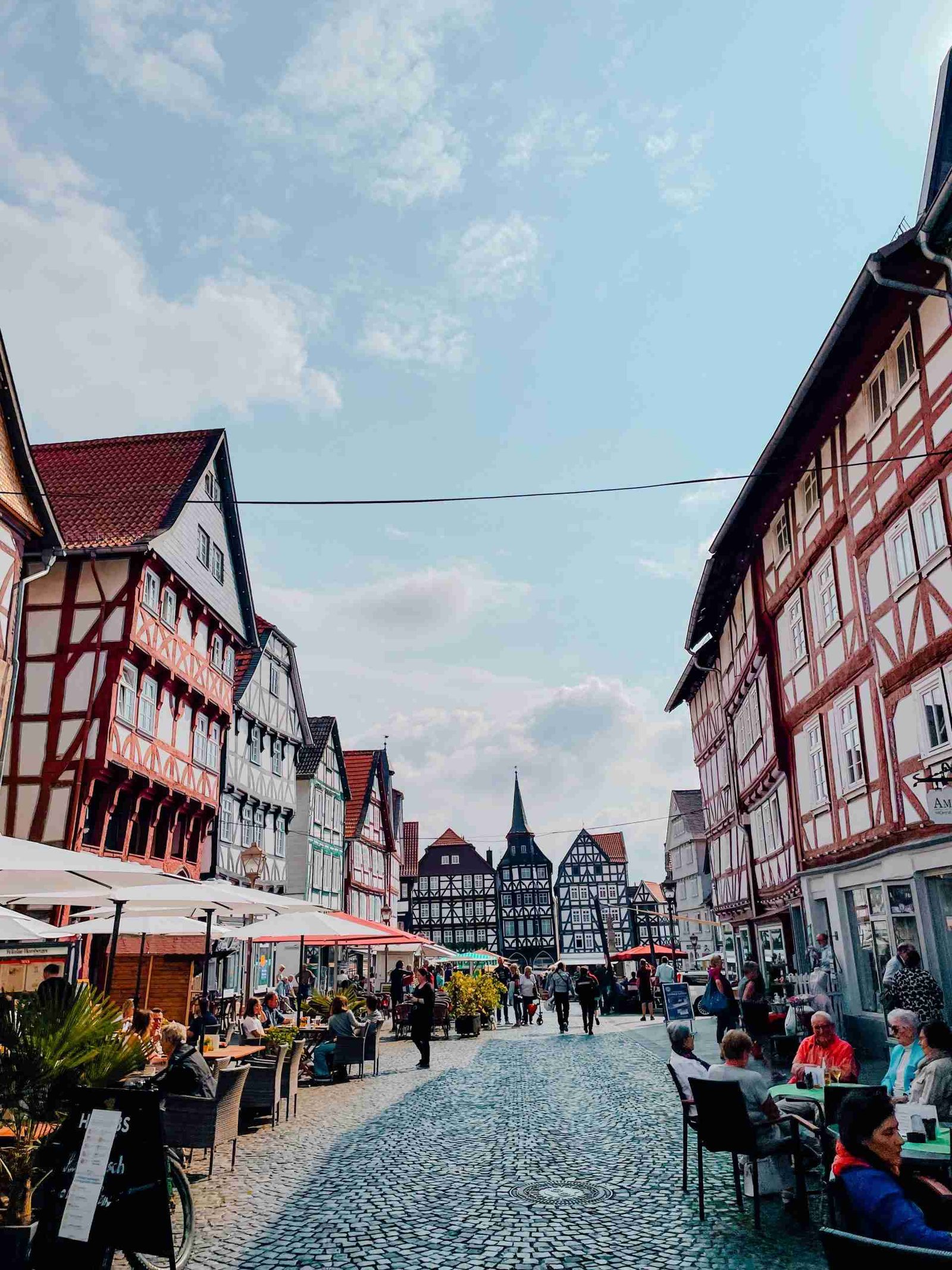 The timber-framed houses in line the streets of Fritzlar on a sunny day with people enjoying drinks on the terrace