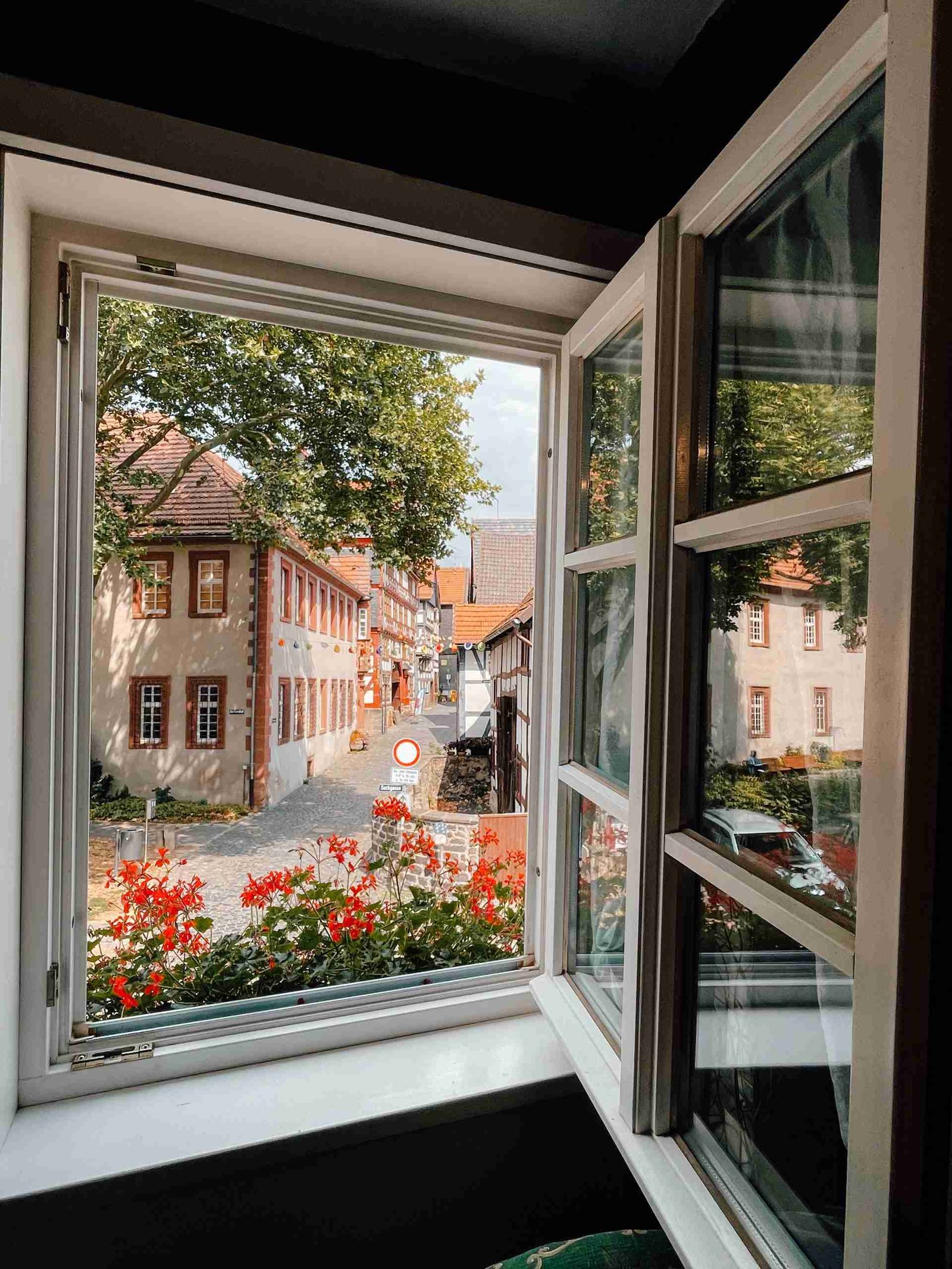 The view of a historic street in a small German town lined with flowers, from inside the fairytale house in Alsfeld