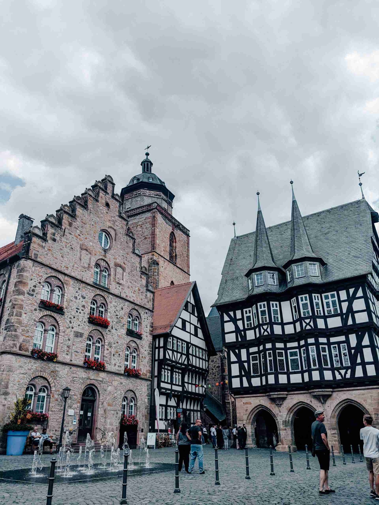 Asfled town square on a cloudy day with fountains to the left and half-timbered buildings to the right - one of my favorite towns on the German Fairy tale route