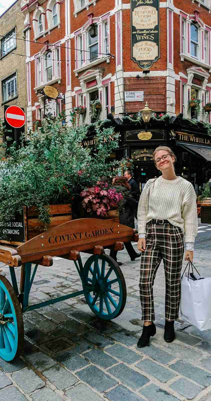 A girl standing in front of a Covent Garden carriage