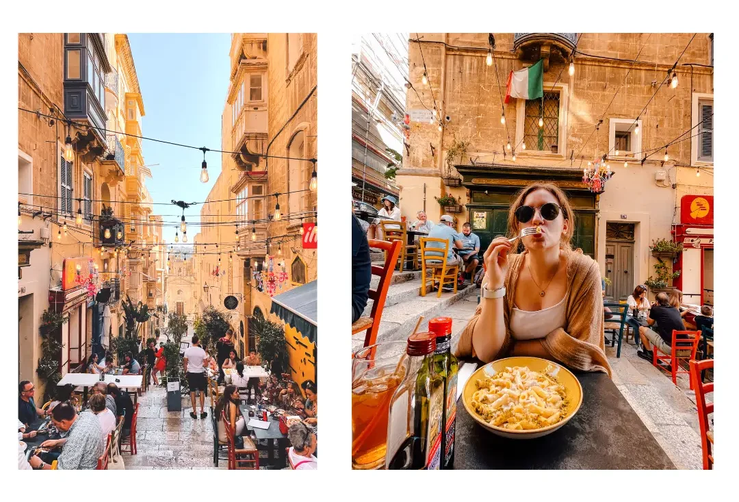 A girl snacking on pasta with a beautiful street with hanging lights behind her
