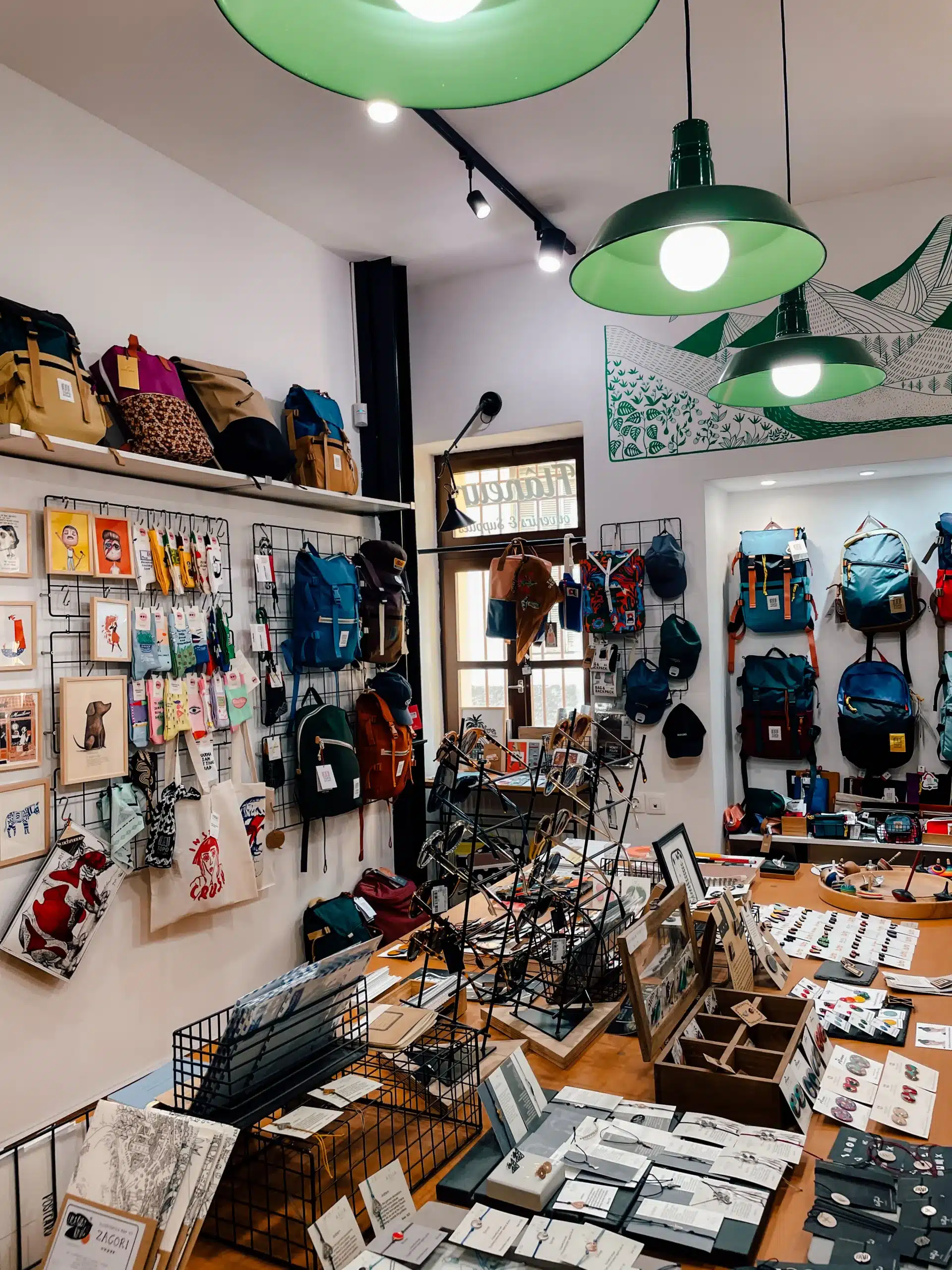 Inside an artists shop in Athens with prints and products on the table and hanging on the walls