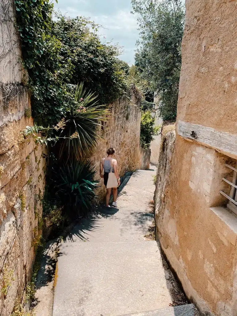 A girl walking down the hidden quiet streets in the medieval town of St. Emillion 
