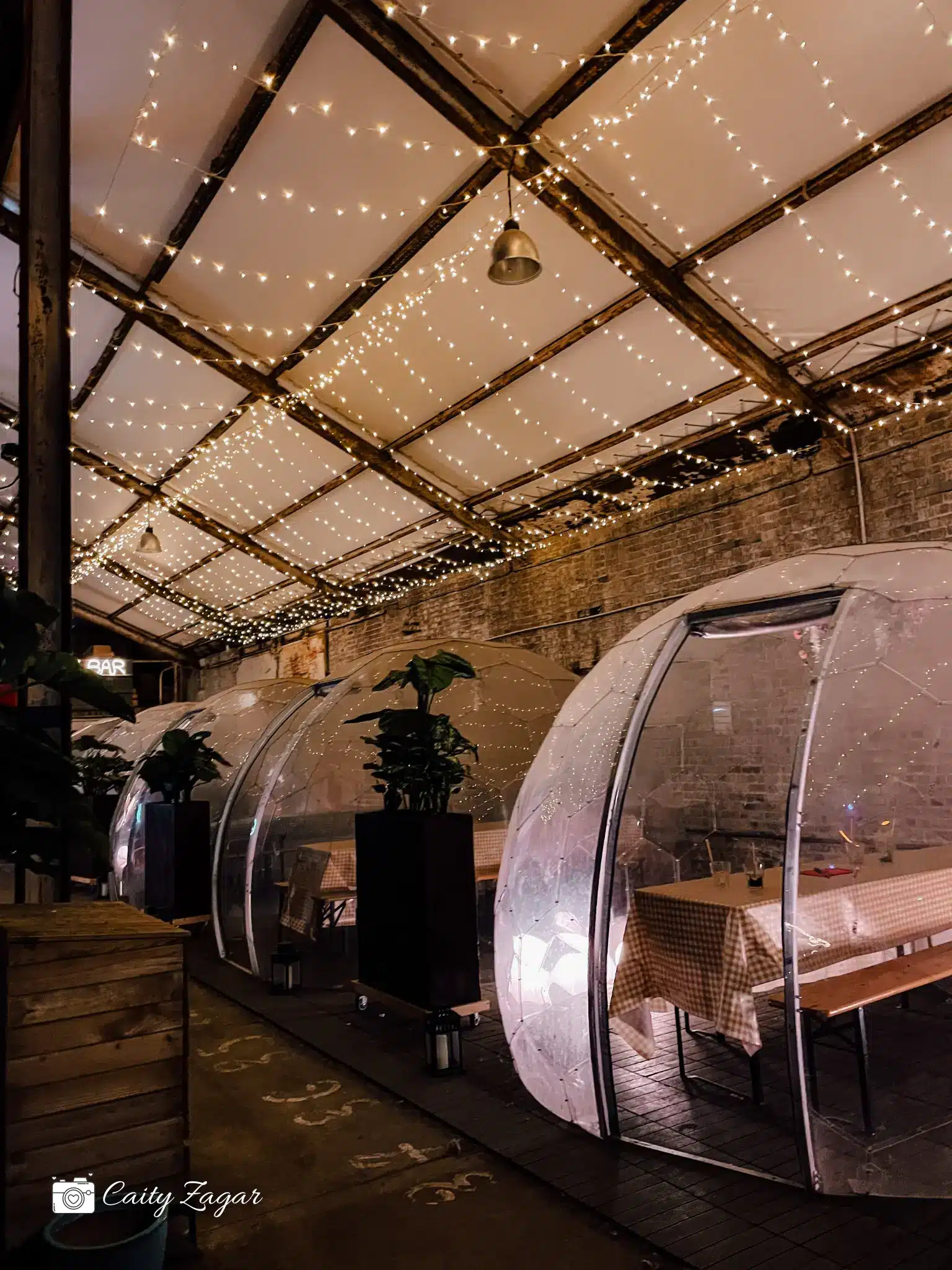 the indoor igloos from la friche gourmande with twinkling lights hanging from the ceiling